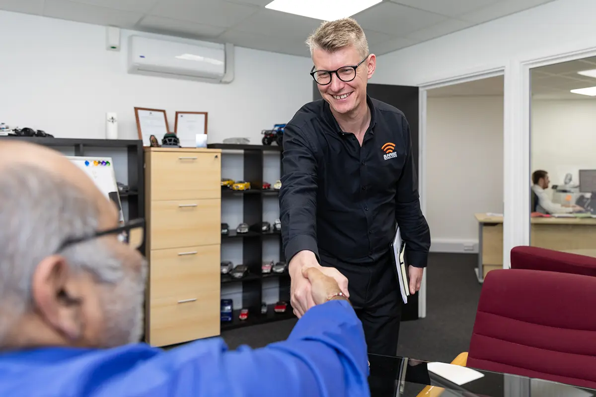 Simon from Sunrise shaking hands with a client in the sunrise office