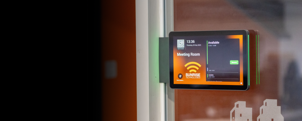 Modern meeting room with front panel scheduling display and integrated video conferencing technology.
